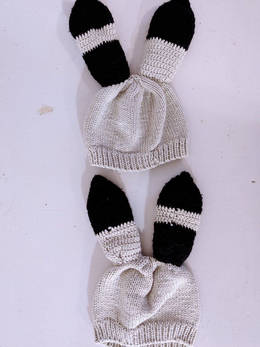 Pair of 2 cute cream-coloured knitted bunny ears beanie caps with black stripes